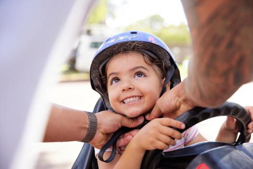 a young child wearing a helmet while riding a motorcycle at RAC Busselton Holiday Park in Busselton