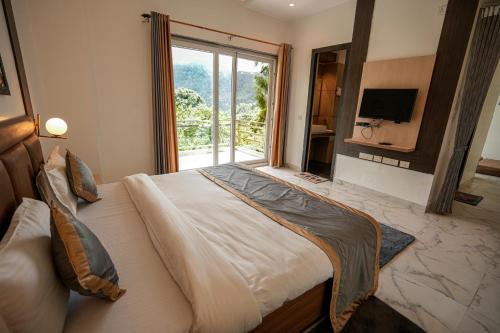 a bedroom with a large bed with a large window at Chirping Hills Resort,Bhimtal in Bhīm Tāl