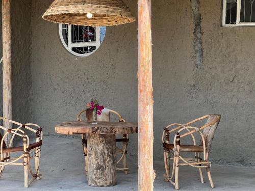 a wooden table with two chairs and a table with flowers on it at Africa Amini Homes in Nkoaranga