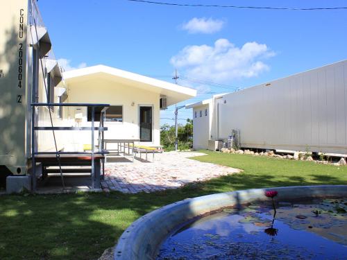 a pool of water in a yard next to a building at ペンション村山里 in Yamazatu