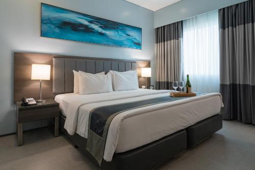 a large bed in a hotel room with two lamps at Bayfront Hotel Cebu North Reclamation in Cebu City