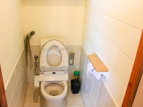 a small bathroom with a toilet with the seat up at ペンション村山里 in Yamazatu