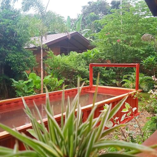 czerwony most przed domem z drzewami w obiekcie At Home annex w mieście Puerto Princesa