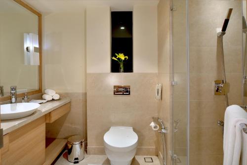 a bathroom with a toilet and a sink and a shower at Golden Sarovar Portico in Amritsar