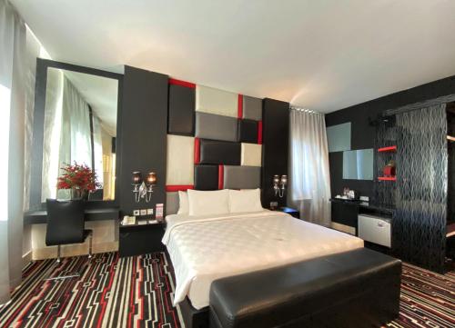 a bedroom with a large bed and a large mirror at Swiss-Belcourt Makassar in Makassar