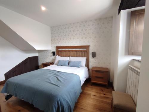 a bedroom with a bed with a blue blanket at PiluPeta Casa de Aldea 