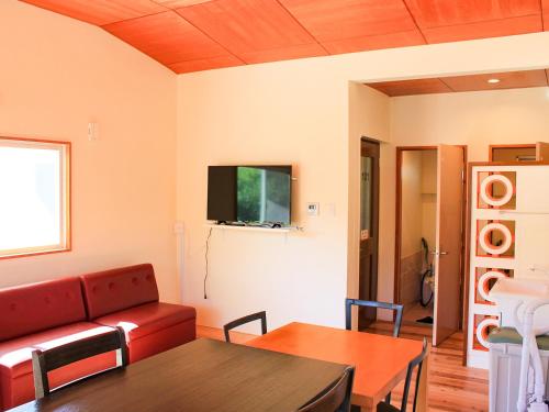 a living room with a couch and a table at ペンション村山里 in Yamazatu