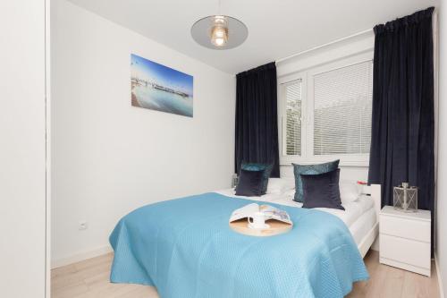 a bedroom with a blue bed with a hat on it at Two-Bedroom Apartament Gdansk 650 m Brzeźno Beach by Noclegi Renters in Gdańsk