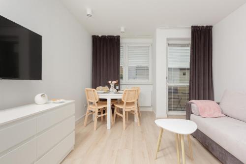 a living room with a table and a couch at Two-Bedroom Apartament Gdansk 650 m Brzeźno Beach by Noclegi Renters in Gdańsk