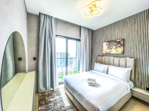 een slaapkamer met een groot wit bed en een raam bij STAY BY LATINEM Luxury 2BR Holiday Home CV B2513 near Burj Khalifa in Dubai