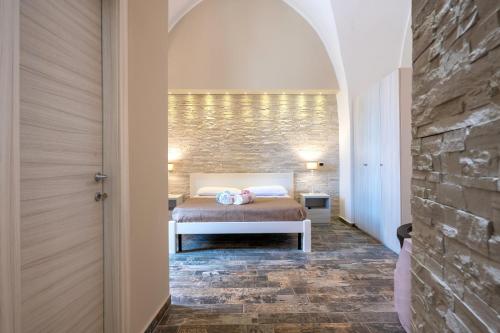 una camera con letto e parete in pietra di Sg Apartment Luxury a Massafra