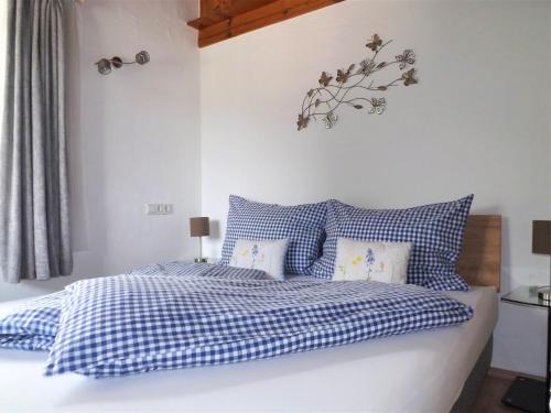 een slaapkamer met een bed met blauwe en witte kussens bij Kaiser Suite, Apartments Scheffau in Scheffau am Wilden Kaiser