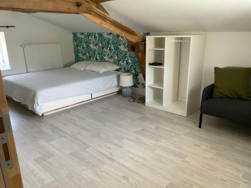 a bedroom with a bed and a couch and a chair at Ravissant appartement dans cadre verdoyant in Marchampt