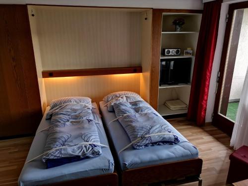 two beds in a small room with a light at B5 Schwarzwald-Fewo an der Alb in Menzenschwand
