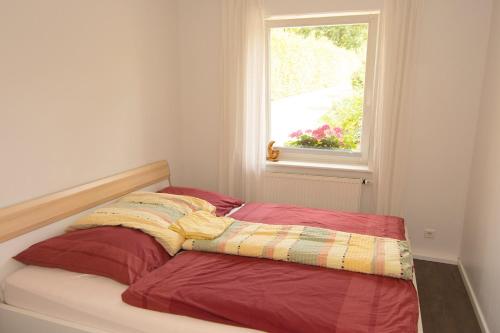 a bed in a room with a window at Ferienwohnung am Sandbarg in Jesteburg