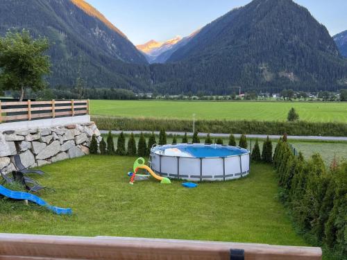 a small pool in a yard with mountains in the background at Chalet in Neukirchen with Mountain Views in Rosenthal