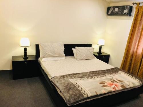 1 dormitorio con 1 cama con 2 lámparas en ambos lados en Fully Luxurious Entire Villa Vacation Home In Bahria Town Phase 8, en Rawalpindi