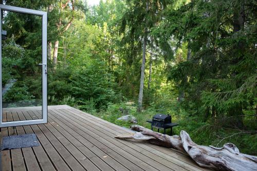 a wooden deck with a grill and a tree stump at Kakupesa Puhkemaja in Hara