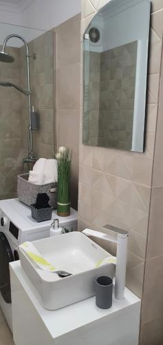 a bathroom with a white sink and a mirror at Sunrise by the Sea in Constanţa