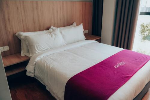 a bed in a hotel room with a colorful blanket on it at Amigo Hotel Bintulu in Bintulu