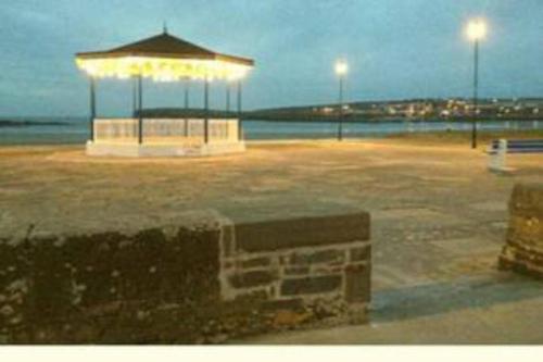 a pavilion in a parking lot near the ocean at night at Luxurious Property, Paddy's Haven, Wild Atlantic Way, County Clare in Kilrush