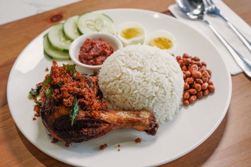 a white plate of food with rice and beans at Amigo Hotel Bintulu in Bintulu