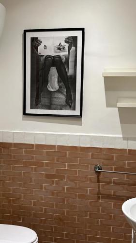 a picture hanging on a wall above a toilet at MammaRo's House in Naples