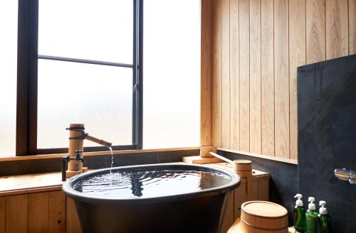 a bath tub in a bathroom with a window at 宮若温泉郷 宮若虎の湯 Miyawaka Toranoyu in Miyawaka