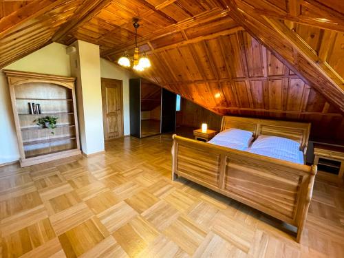 1 dormitorio grande con 1 cama y techo de madera en Dom na Poniatowie, en Wałbrzych