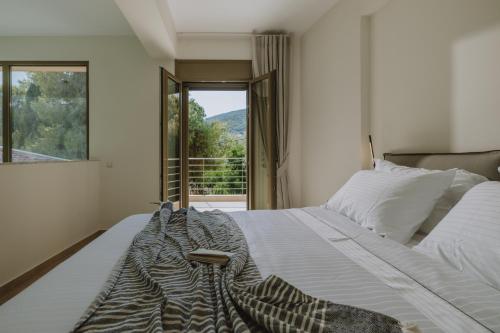 ein Schlafzimmer mit einem großen Bett und einem Fenster in der Unterkunft Paleros Bay Villas in Palairos
