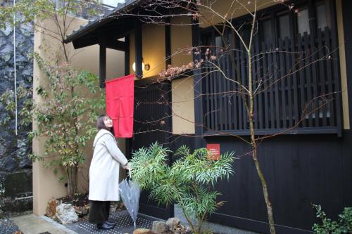 a man is standing outside of a house at 龍馬坂荘：1日1組限定・東山清水のてっぺんの小さなお宿、わんこと一緒に。 in Kyoto