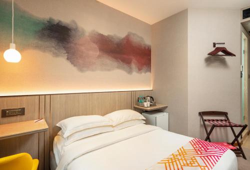 a bedroom with a bed and a painting on the wall at Ginger Mumbai, Goregaon in Mumbai