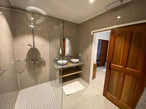a bathroom with two sinks and a glass shower at Coin D'or in Anse Possession