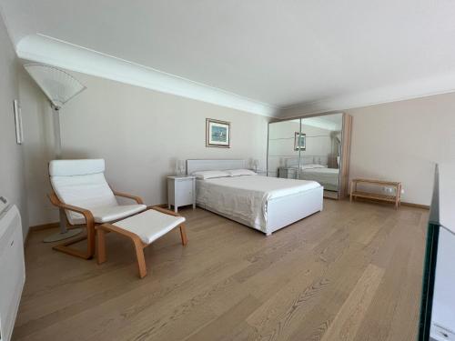 a bedroom with a bed and a chair and a mirror at Luxury Loft on the Sea in Trapani