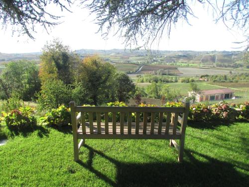a wooden bench sitting on top of a lush green field at Villa Fontana Relais Suite & Spa in Agliano Terme