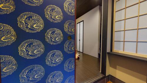 a hallway with a blue and gold patterned wall at 龍馬坂荘：1日1組限定・東山清水のてっぺんの小さなお宿、わんこと一緒に。 in Kyoto