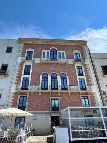 a large brick building with windows and a balcony at Luxury Loft on the Sea in Trapani