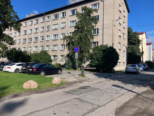a street with cars parked in front of a large building at Find for the traveler in Tallinn
