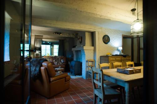 een keuken en een woonkamer met een tafel en stoelen bij GITE AU BORD DE L'AISNE in Érezée