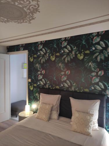 ein Schlafzimmer mit einem großen Bett mit Blumentapete in der Unterkunft APPARTEMENT NANCY THERMAL/ARTEM/PARC STE MARIE Le 61 LES THERMES in Nancy