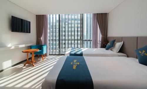 um quarto de hotel com duas camas e uma janela em The Time Hotel em Nha Trang