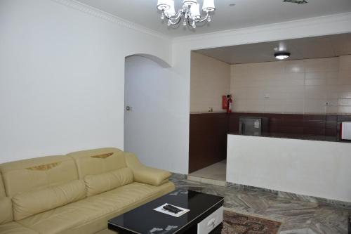 a living room with a couch and a table at Royal Suite Hotel Apartments in Al Ḩuwayl
