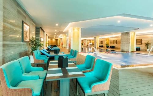 a hotel lobby with blue chairs and a swimming pool at NHA TRANG COMFORTZONE APARTMENT in Nha Trang