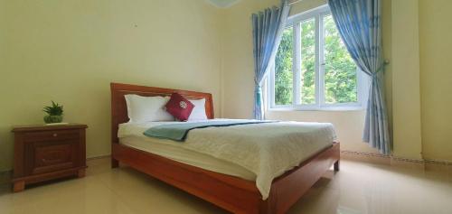 a bedroom with a bed and a window at Hoan Chau Homestay in Phong Nha