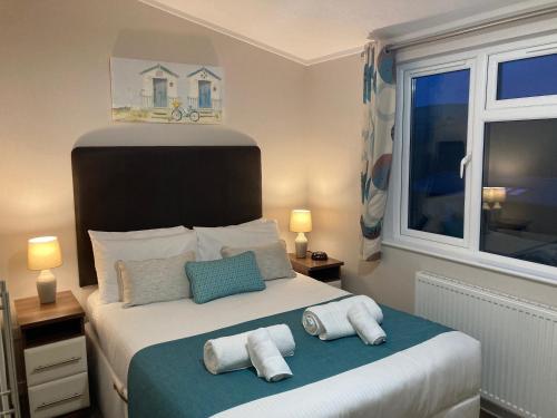1 dormitorio con 1 cama con toallas en 23 Bossiney Bay, en Tintagel