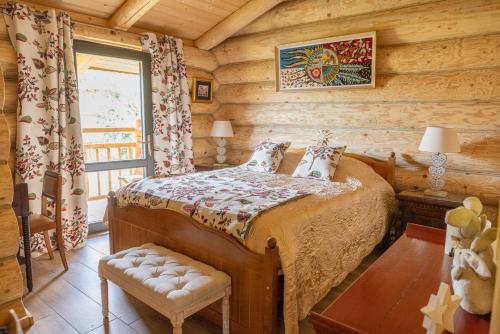 ein Schlafzimmer mit einem Bett in einem Blockhaus in der Unterkunft Les Flocons de Neige in Bolquere