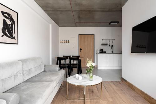 a living room with a couch and a table at Apartamenty Przystanek Morska in Gdynia