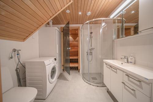 a bathroom with a washing machine and a shower at Levillas Sointuilevi 1B66, 2 ski pass included in Levi