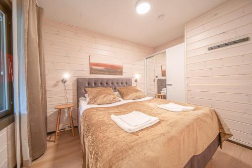 a bedroom with a bed with two towels on it at Levillas Sointuilevi 1B66, 2 ski pass included in Levi