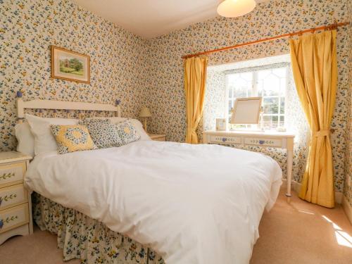 a bedroom with a bed and a window at Vine Cottage in Minehead
